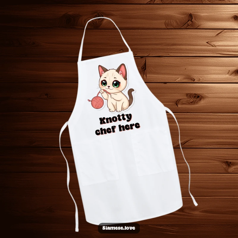 Funny Kawaii Siamese Cat Apron: Whimsical cat with wide eyes playfully batting at a dangling yarn ball, perfect for a fun kitchen.