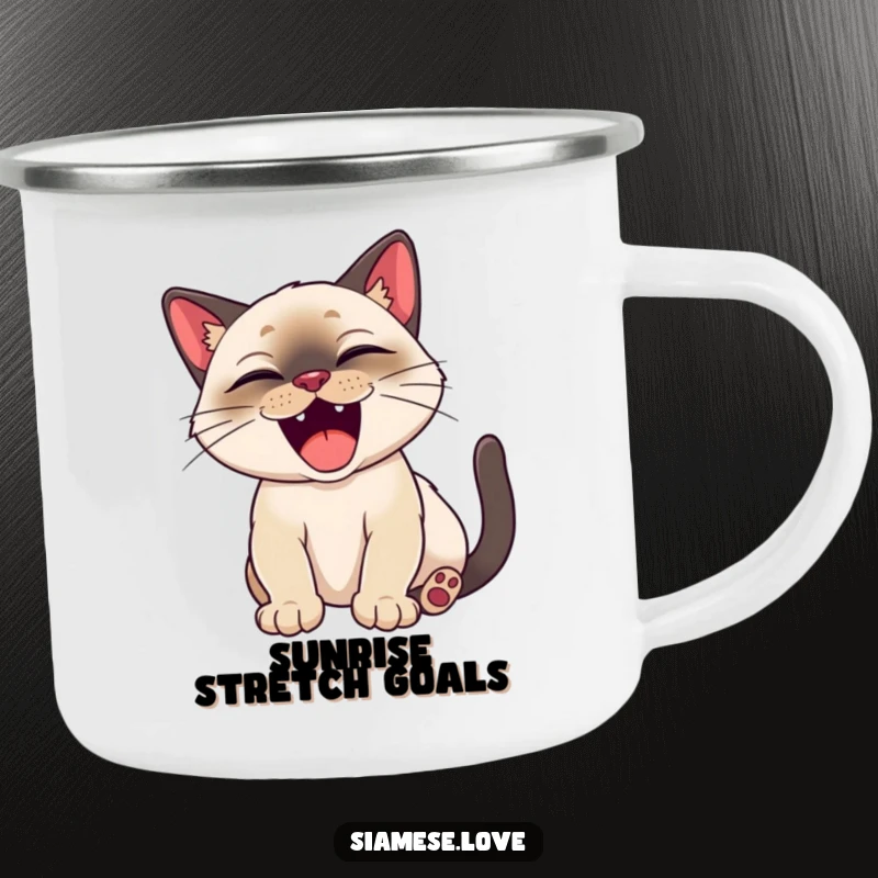 Funny Siamese cat happily stretching with a big, satisfied yawn on an enamel camping mug.