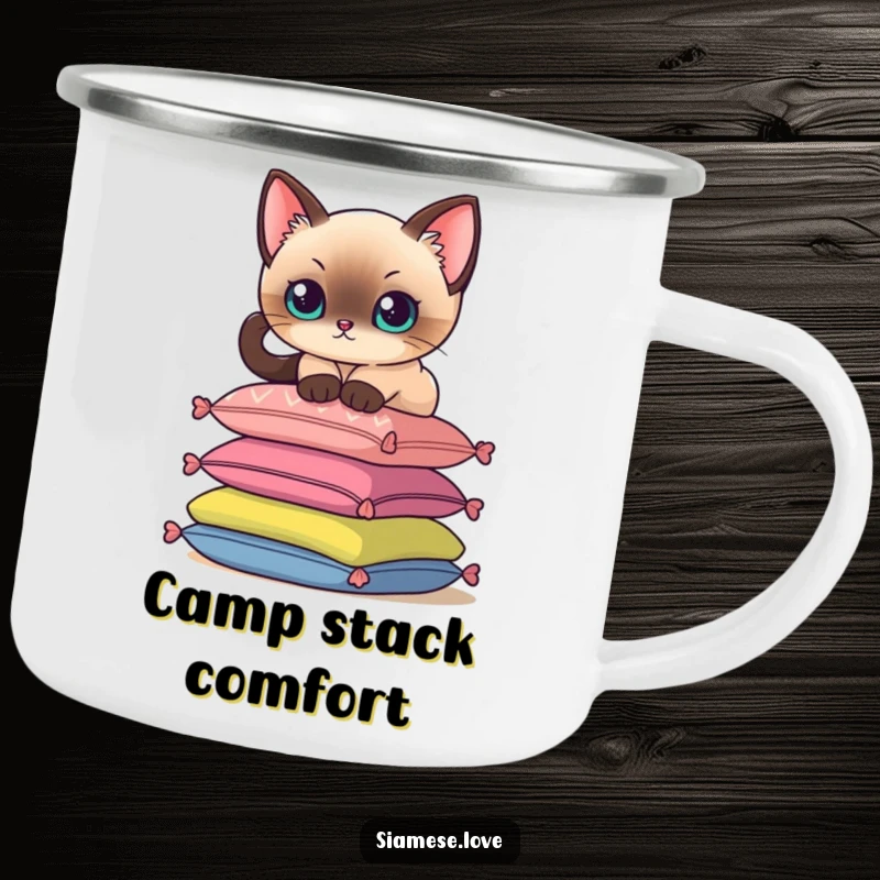 Funny camping mug with a Siamese cat delicately perching on a stack of colorful cushions, durable for outdoor use.