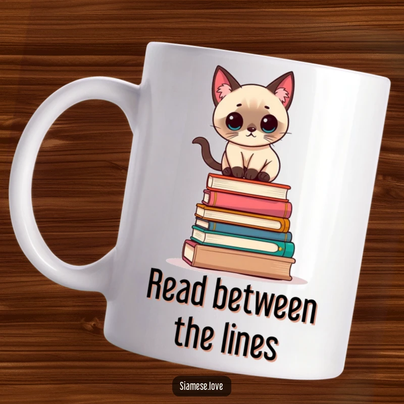 Funny Kawaii Siamese cat balancing precariously on a stack of books, depicted on a ceramic mug.
