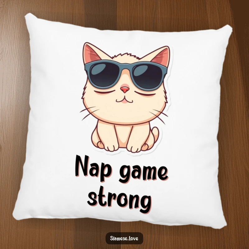 Funny Siamese cat comically wearing oversized sunglasses on a decorative pillow, adding sleepy charm.