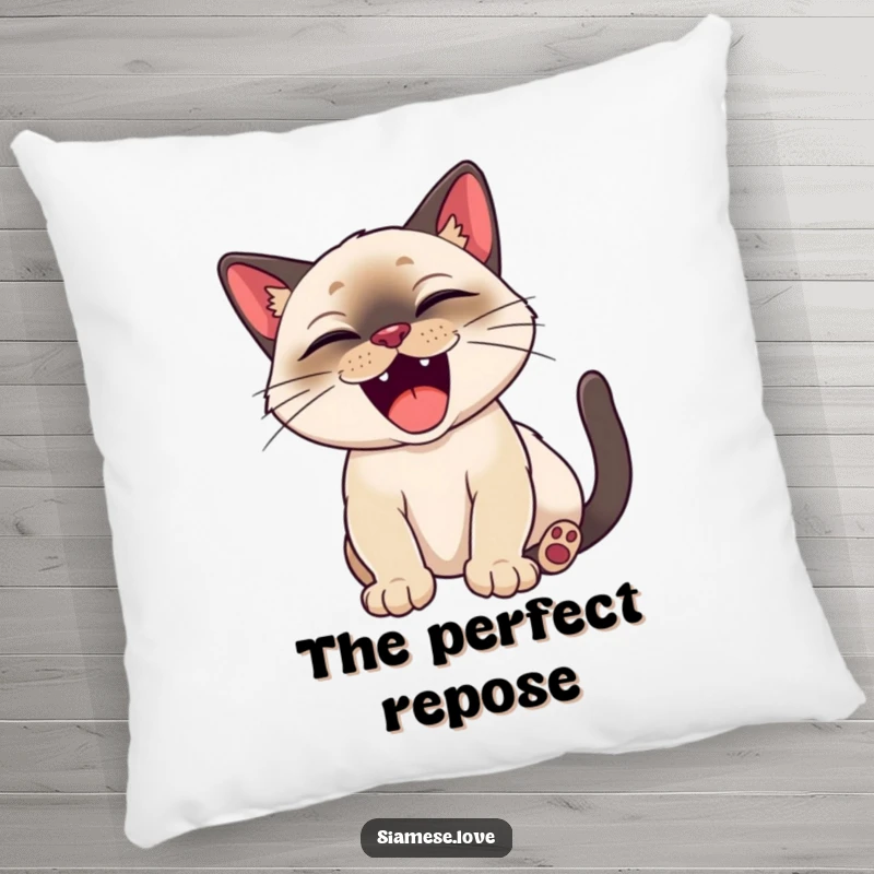 Funny Siamese cat happily stretching with a big, satisfied yawn on a decorative pillow.
