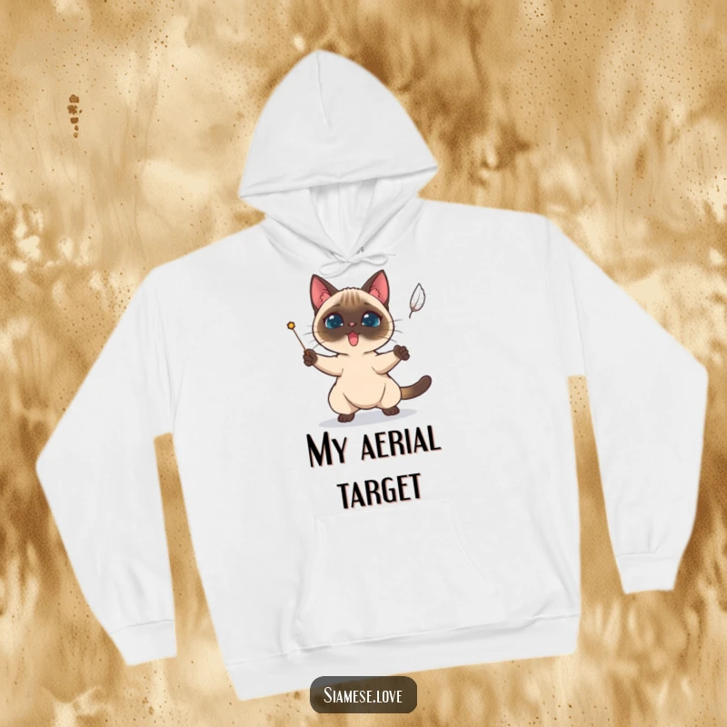 Funny Siamese cat character determinedly attempting to catch a falling feather, featured on a cozy hoodie.