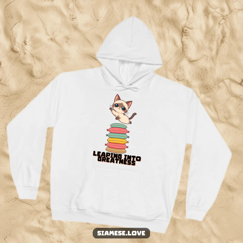 Funny and warm hoodie featuring a Siamese cat mid-leap onto a stack of colorful cushions. Comfortable and chic.
