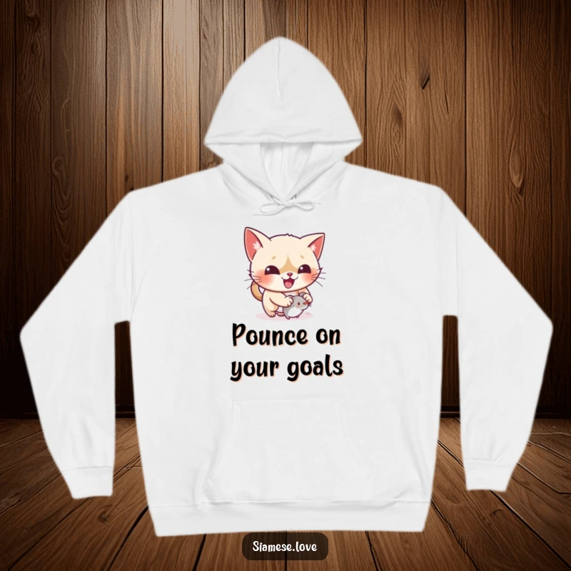 Funny kawaii Siamese cat pouncing on a toy on a warm hoodie, embodying playful excitement.