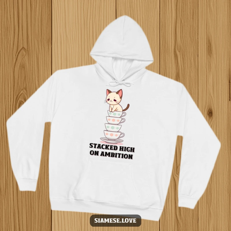 Funny Siamese cat hoodie, feline balancing act on stacked teacups, cozy and comical, ideal funny gift for cat lovers.