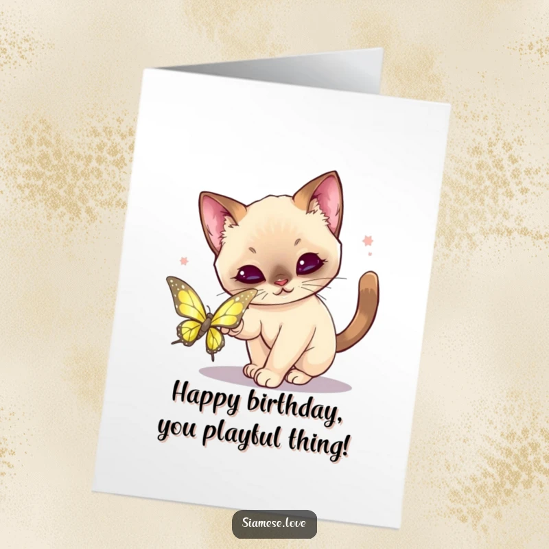 Funny Free Printable Birthday Card: Kawaii Siamese cat playfully pouncing on a shimmering butterfly, a humorous chase.