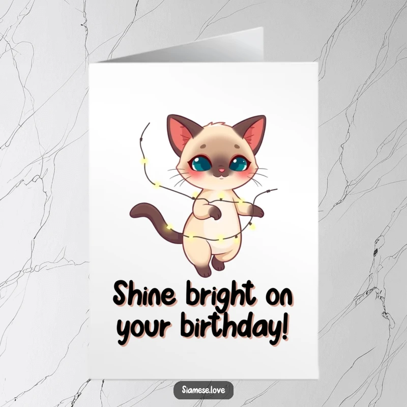 Funny Free Printable Birthday Card: Graceful Siamese cat joyfully twirling with a magical string of sparkling lights, festive design.