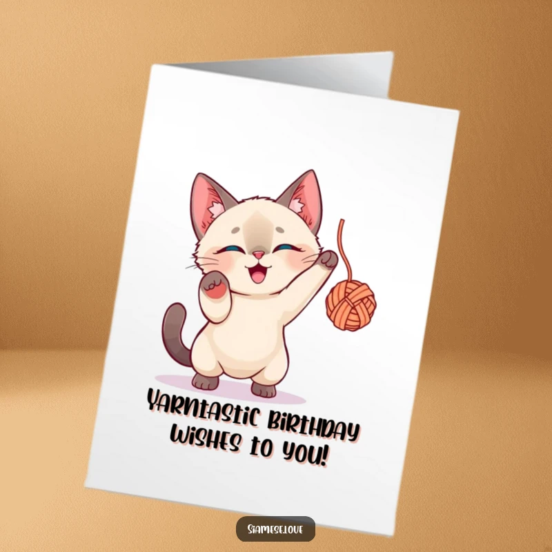 Funny Free Printable Birthday Card: Siamese Cat enthusiastically batting a yarn ball, pure feline joy, printable greeting.