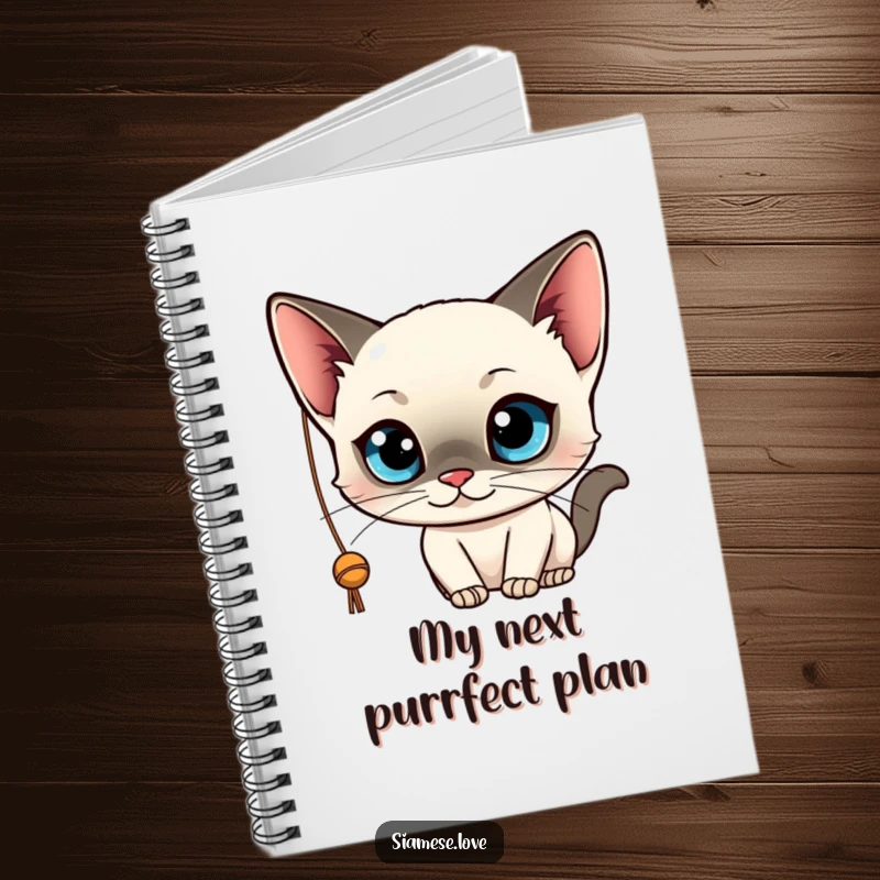Funny notebook featuring a kawaii Siamese cat with big blue eyes, playfully batting at a string. Ideal for notes and journaling.