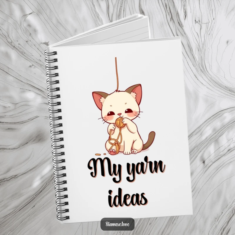 Funny notebook with a cute kawaii Siamese cat batting playfully at a dangling yarn ball, perfect for note-taking.