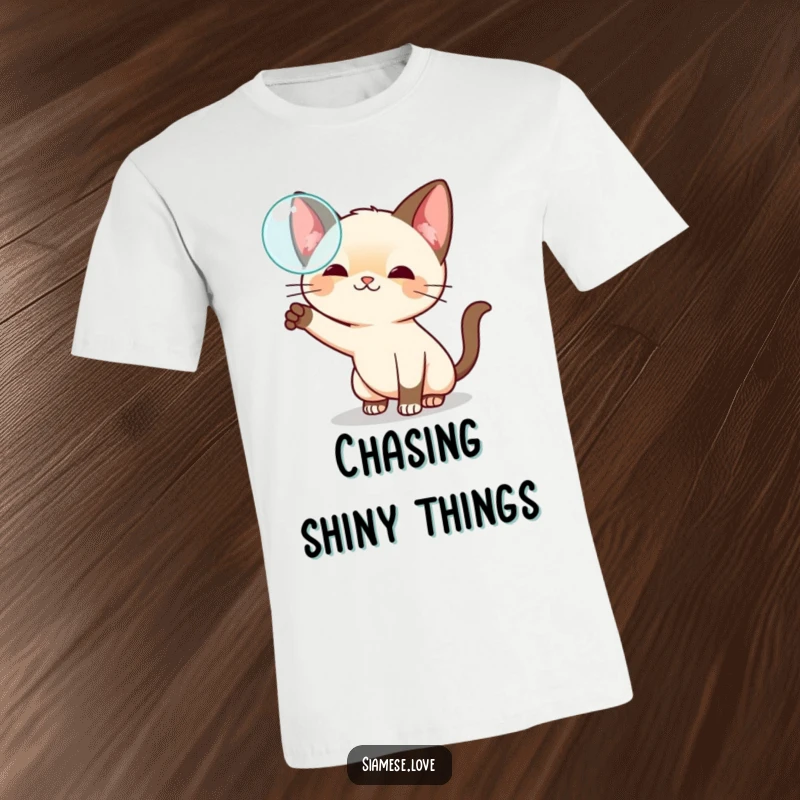 Funny kawaii Siamese cat t-shirt, playfully swatting at a floating bubble, showcasing lighthearted fun and curiosity.