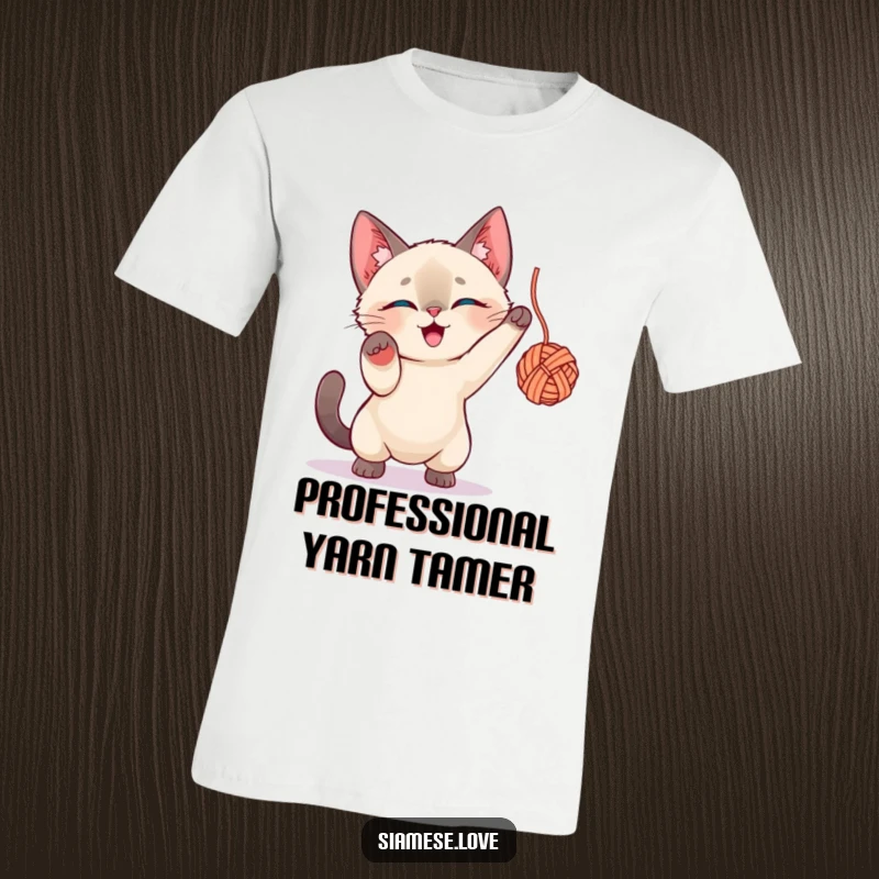Funny Siamese Cat T-Shirt: Playful cat character fiercely attacking a dangling yarn ball with intense focus.