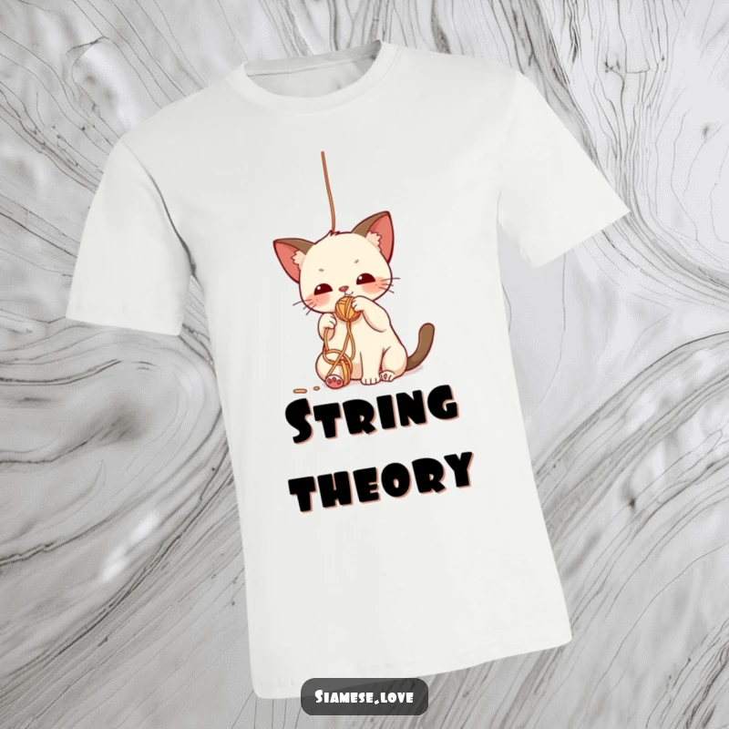 Funny t-shirt with a cute kawaii Siamese cat batting playfully at a colorful dangling yarn ball, showcasing feline mischief.
