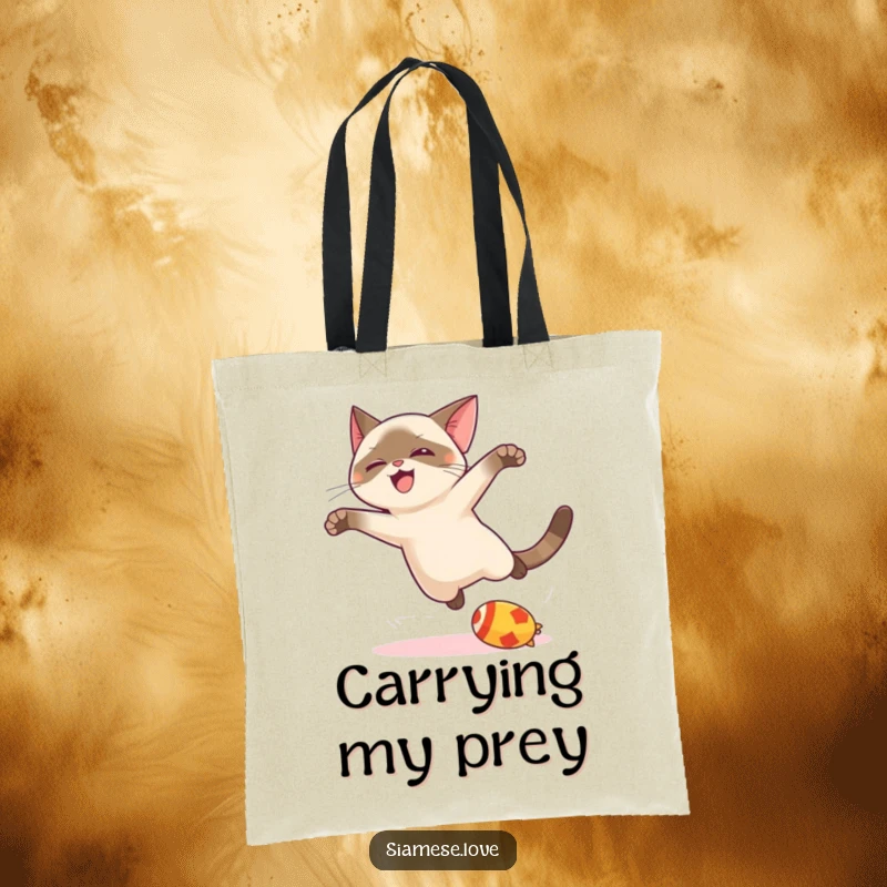 Funny kawaii Siamese cat tote bag, mid-leap with a toy, showcasing playful energy and adorable feline charm for shoppers.