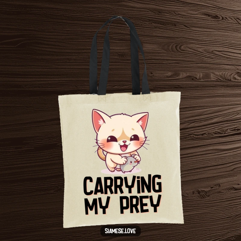 Funny kawaii Siamese cat gleefully pouncing on a small mouse toy on a tote bag, ready for action.