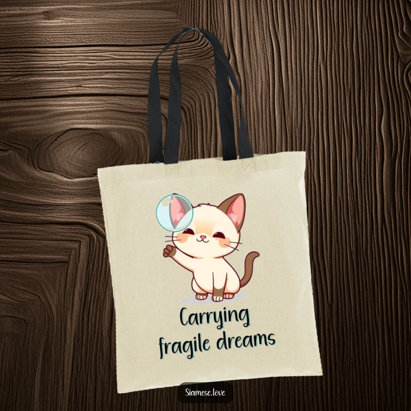 Funny kawaii Siamese cat tote bag, playfully swatting at a floating bubble, ideal for carrying items with whimsical flair.