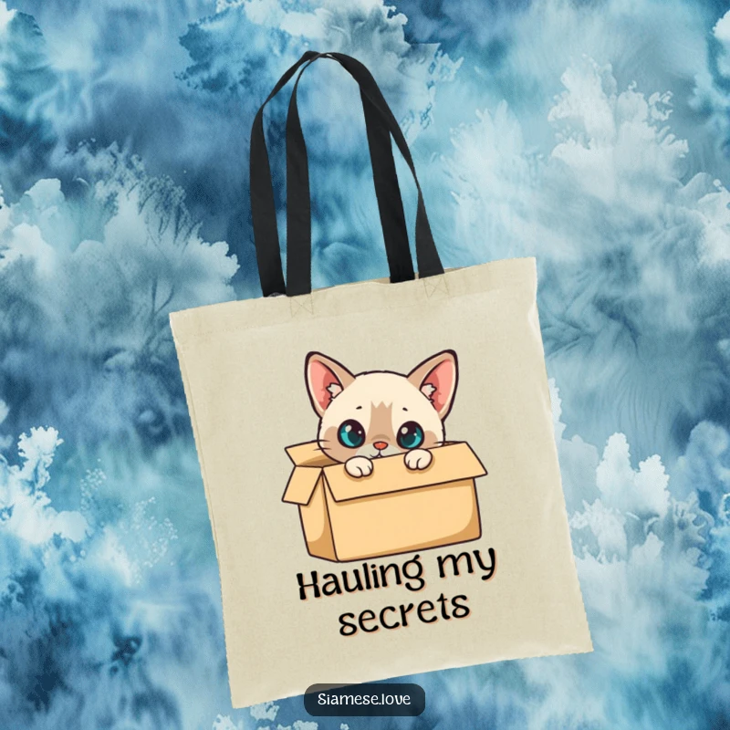 Funny Tote Bag: A curious Siamese cat peeking from a cardboard box, hinting at hidden treasures and fun.
