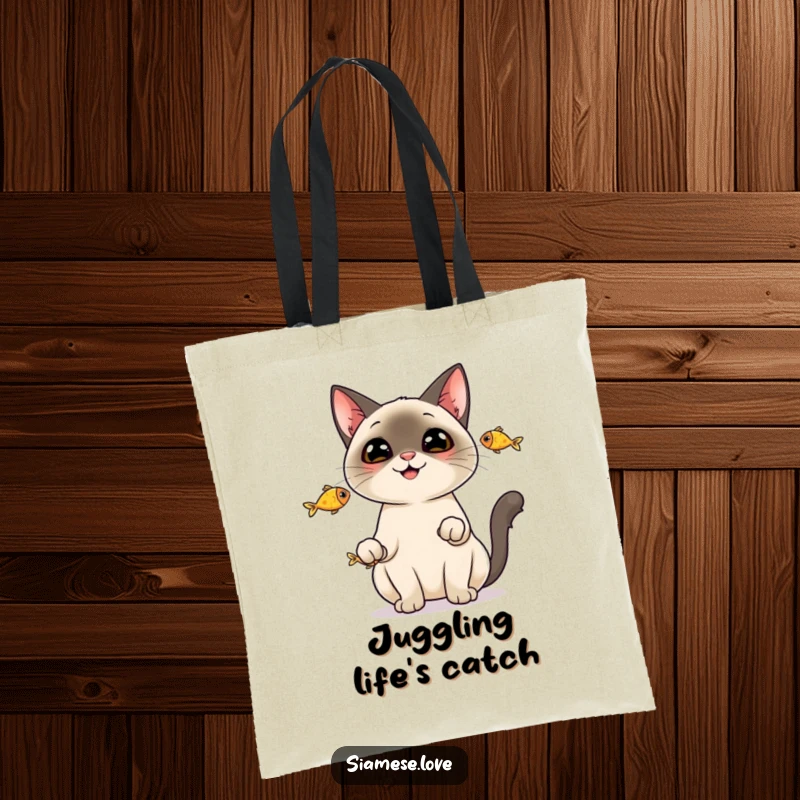 Funny Tote Bag: A cheerful Siamese cat juggling three fish, demonstrating its playful and impressive abilities.