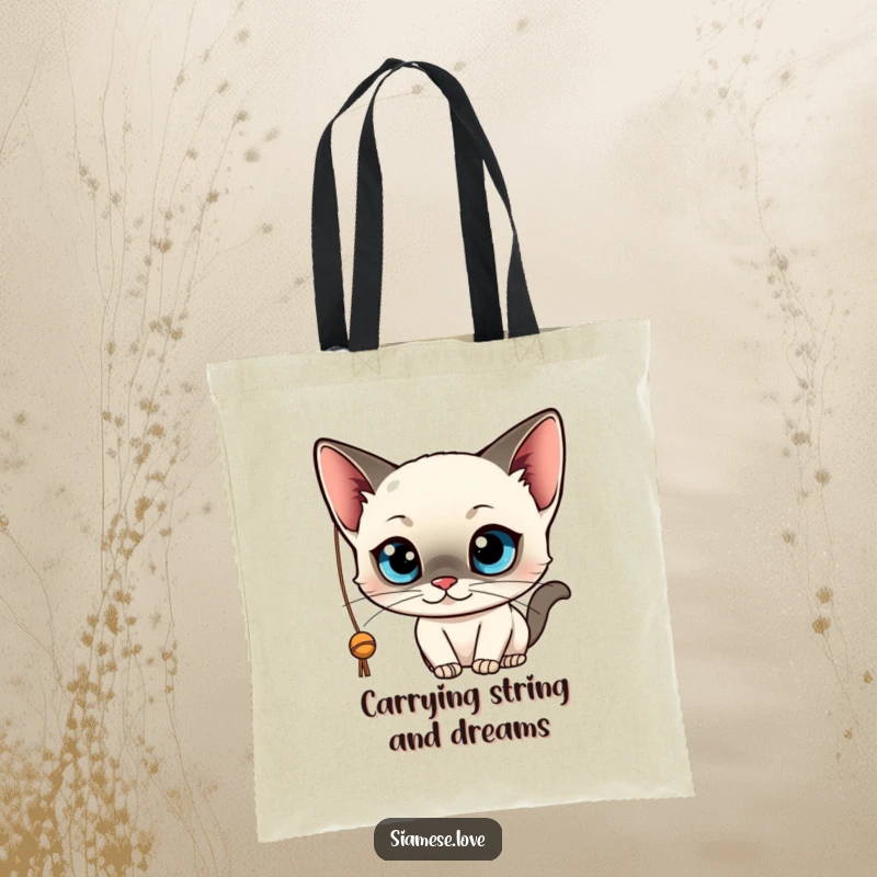 Funny tote bag featuring a sleek, kawaii Siamese cat with big blue eyes, playfully batting at a string. Practical and cute.