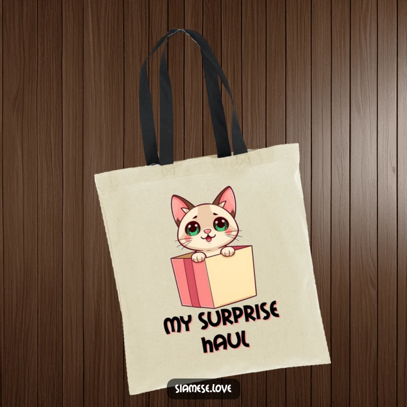 Funny Siamese cat emerging from a gift box with a surprised expression on a tote bag, perfect for carrying essentials.